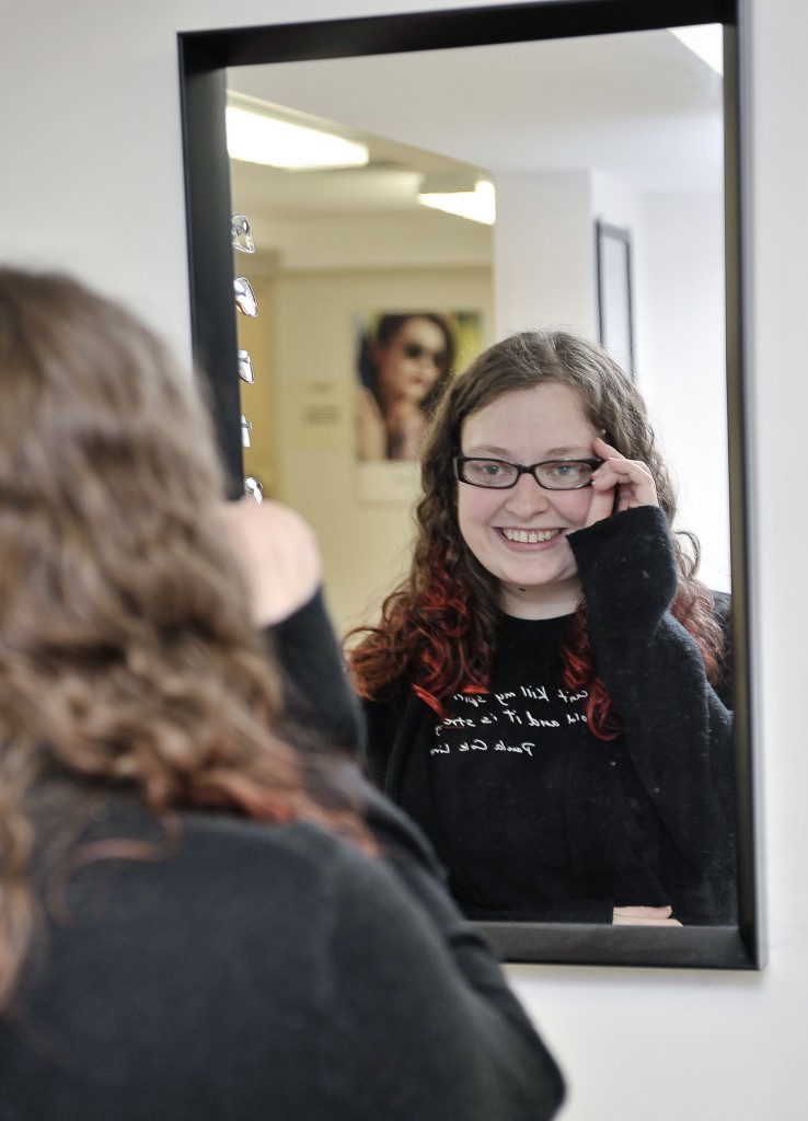 Photo of a woman trying on a pair of eyeglasses.