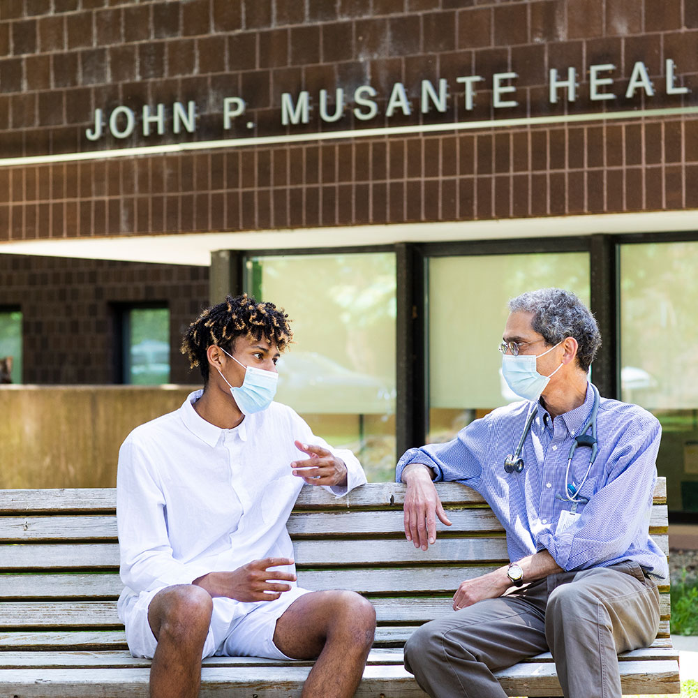 Doctor speaking with young patient outside
